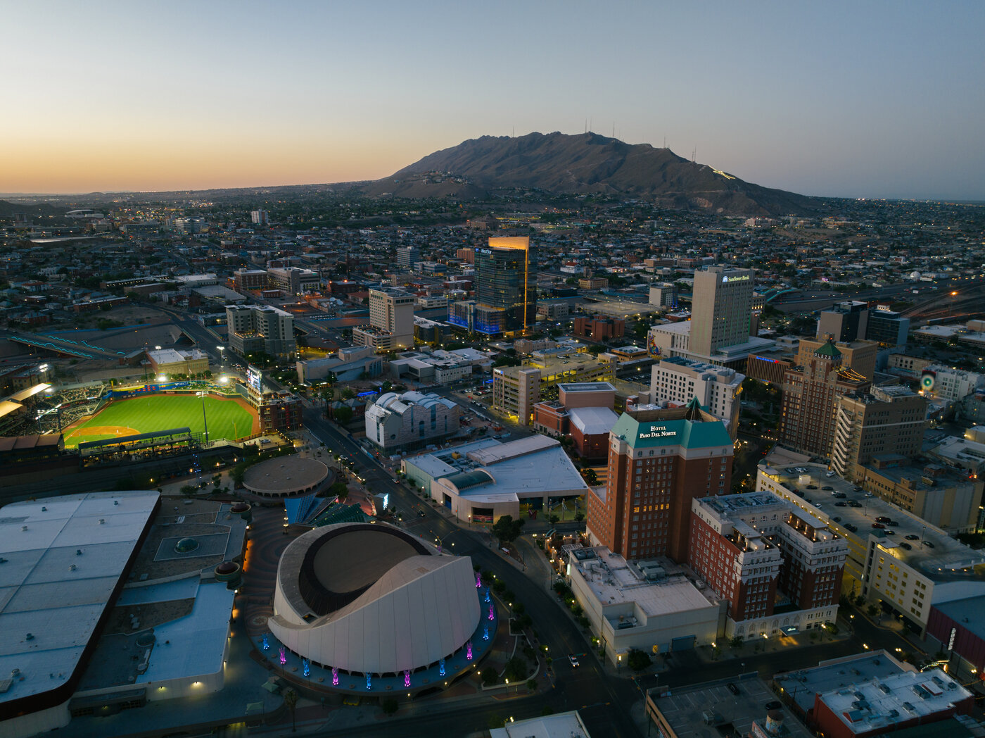 The Den El Paso homepage hero — downtown El Paso at evening